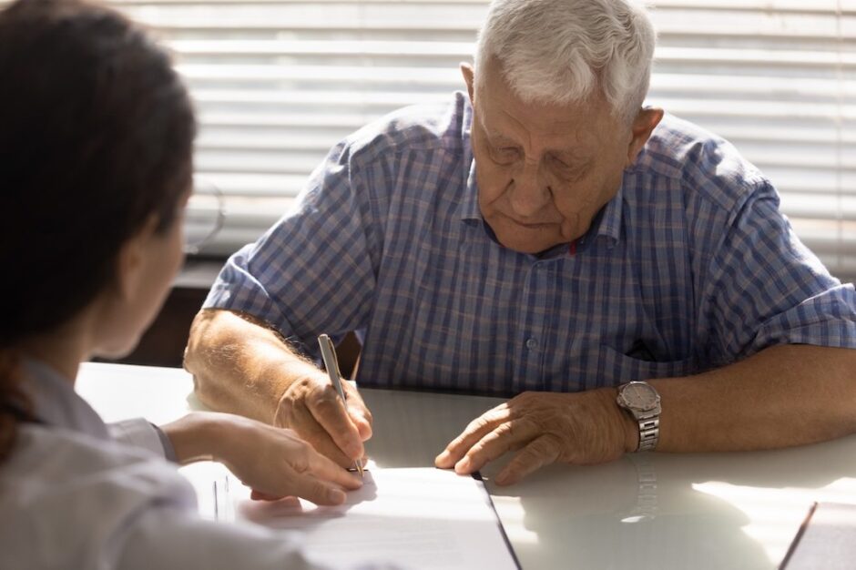 Older man signing a will in his attorney's office